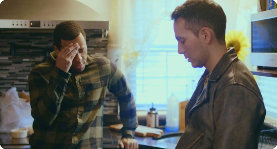 Two men speaking to each other in a kitchen